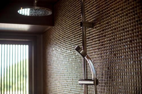 a shower in a bathroom with a tile wall at Sakaeya in Yamanouchi