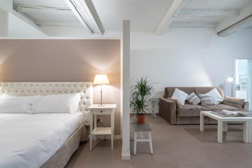 a white bedroom with a bed and a couch at Casa Bacìomari in Bologna