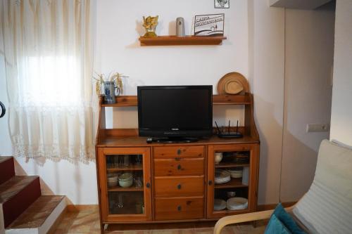 a television on a wooden cabinet in a living room at Caseta Montanyana in Deltebre