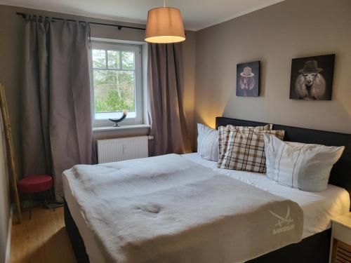 圣彼得奥尔丁Ferienwohnung Deichglück - Direkt am Böhler Sandstrand的卧室里有一张铺着白色床单的床和一扇窗户