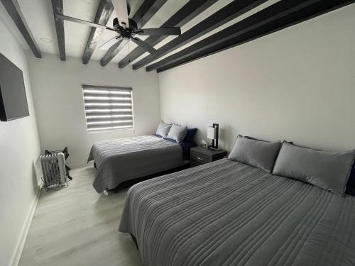 ein Schlafzimmer mit zwei Betten und einem Deckenventilator in der Unterkunft Ocean View, Private, Quiet in Chapultepec