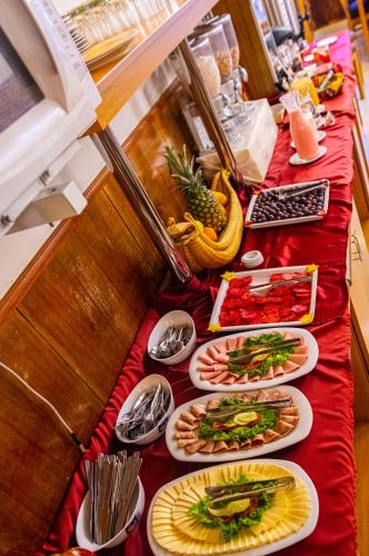 a long red table with plates of food on it at Casona Plaza Balsa Inn in Puno