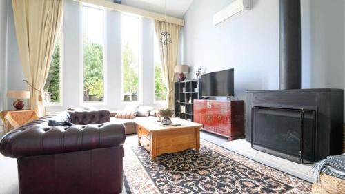 a living room with a leather couch and a fireplace at Akyra in Trentham