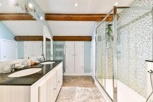 a bathroom with two sinks and a shower at Dovecote - sanctuary in the sky in London