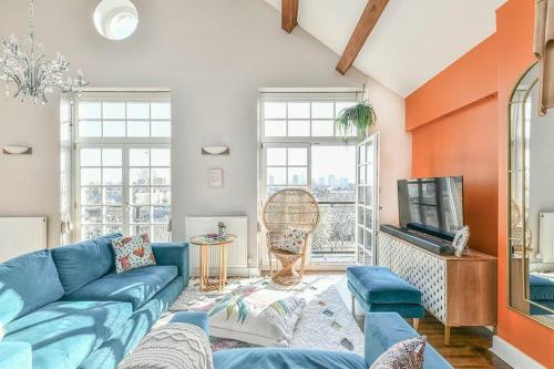 un soggiorno con divano blu e TV di Dovecote - sanctuary in the sky a Londra