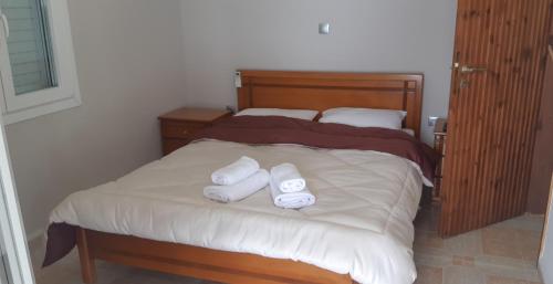 un letto con due asciugamani arrotolati sopra di Α Peaceful Nest a Volímai