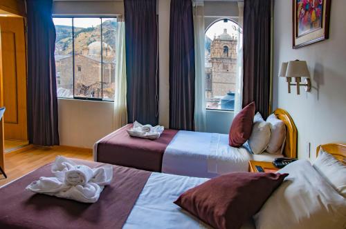 a hotel room with two beds and a window at Casona Plaza Balsa Inn in Puno