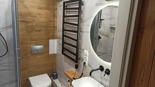 a bathroom with a sink and a mirror at Underground Apartament in Łomża