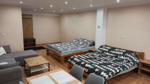 a living room with two beds and a couch at Underground Apartament in Łomża