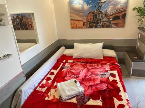 a bed with a red comforter in a room at CORTICELLA 1 in Bologna