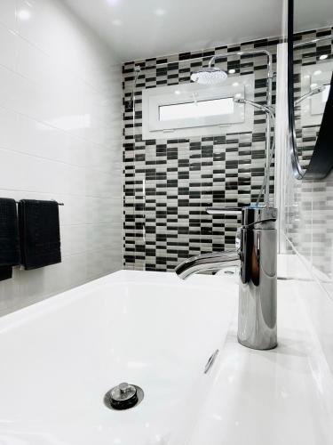a bathroom with a sink with a mixer on a counter at Relaxing upper floor Apartment- exclusive complex. in Los Pocillos
