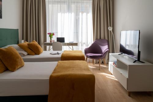 een hotelkamer met een bed en een televisie bij Happy House Apartamenty in Krakau