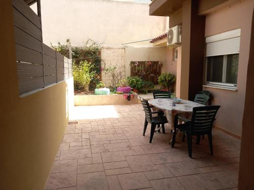 a patio with a table and chairs in a courtyard at Airport's Close, Cozy Flat for 6 Persons in Markopoulo