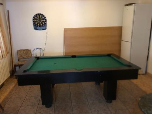 a green pool table in a room with a refrigerator at Chata Oravská Priehrada in Námestovo