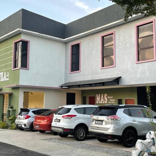 a group of cars parked in front of a building at Villa Motel Mas Guesthouse in Batang Berjuntai