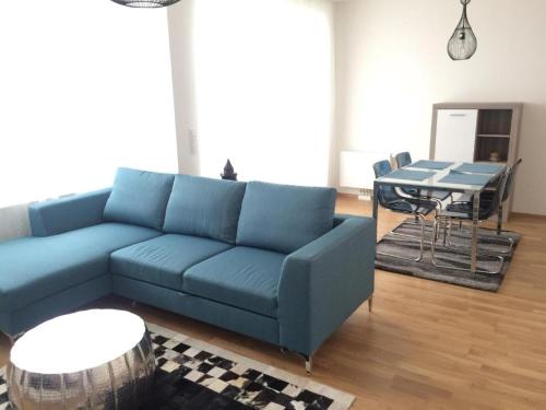 ein Wohnzimmer mit einem blauen Sofa und einem Tisch in der Unterkunft Vienna Belvedere und Hauptbahnhof Apartment in Wien