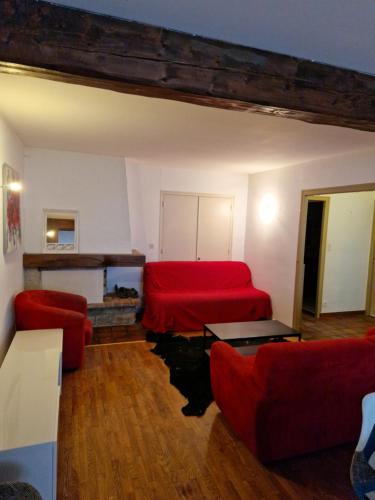 a living room with a red bed and a couch at hypercentre meublé in Clairvaux-les-Lacs