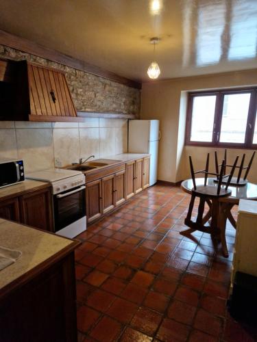 a kitchen with a table and a stove top oven at hypercentre meublé in Clairvaux-les-Lacs