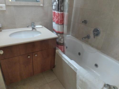 uma casa de banho com um lavatório e uma banheira em Marina vaction rentals em Herzliyya B