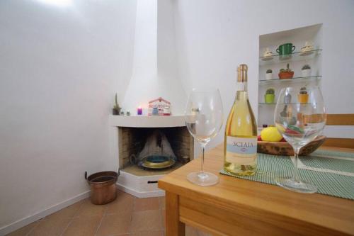 two wine glasses sitting on a table with a fireplace at Santa Caterina in Brindisi