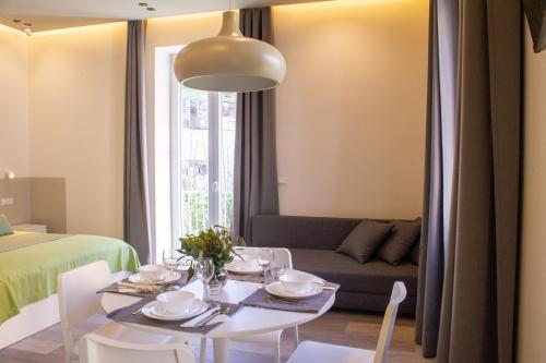 a dining room with a table and a couch at Sirena Partenope e San Gennaro HOME - Rione Sanità - Centro Storico Napoli in Naples