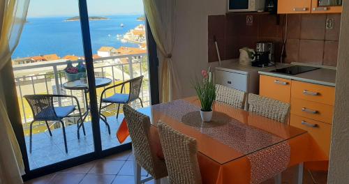 una cucina con tavolo e vista sull'oceano di Apartment Pečarević - a holiday with a stunning view a Vis