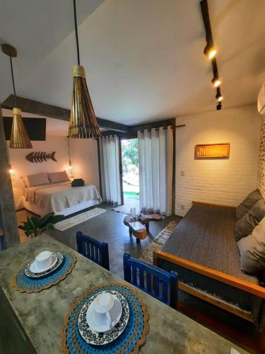 een woonkamer met een bed en een eettafel bij Estudio Lirios seu cantinho ecológico na natureza in Marau