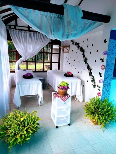two beds in a room with two tables at Hotel Bosque de la Villa in Villa de Leyva