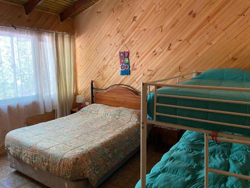 a bedroom with two bunk beds in a cabin at Camping y Cabañas Playa Caliboro in Los Ángeles