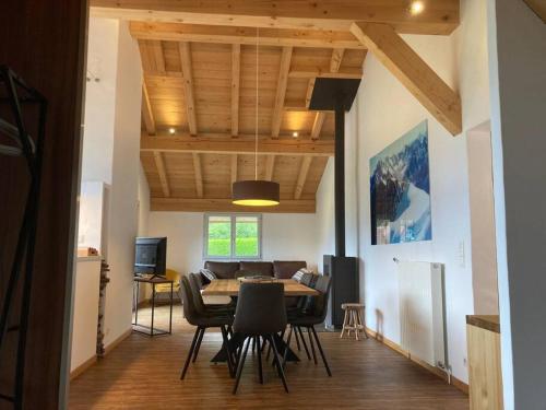 une salle à manger et un salon avec une table et des chaises dans l'établissement Le Montagny - Conciergerie de la Yaute, à Sallanches