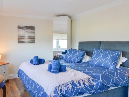 a bedroom with a blue bed with blue pillows at Ailsa Craig View in Stranraer