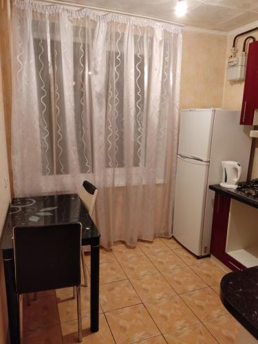 a small kitchen with a table and a refrigerator at Комфортная квартира!!! in Tiraspol