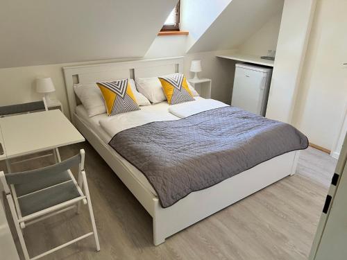 a bedroom with a bed and a table and a chair at Garni pension U svatého Urbana in Mikulov