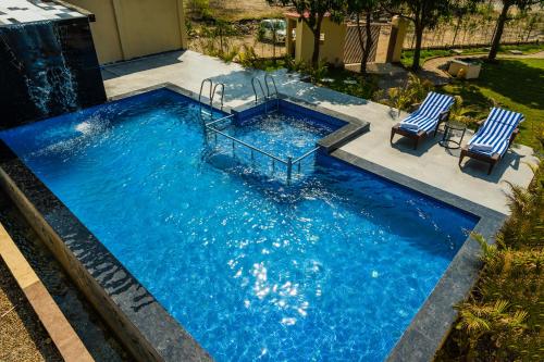 uma piscina com duas cadeiras e uma piscina em Xomotel Blue River em Belparāo