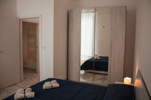 ein Schlafzimmer mit einem Spiegel und einem Bett mit Handtüchern in der Unterkunft Casa Morrone Residence in Corato
