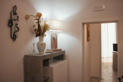 ein Zimmer mit einem Tisch und einer Vase darauf in der Unterkunft Casa Morrone Residence in Corato