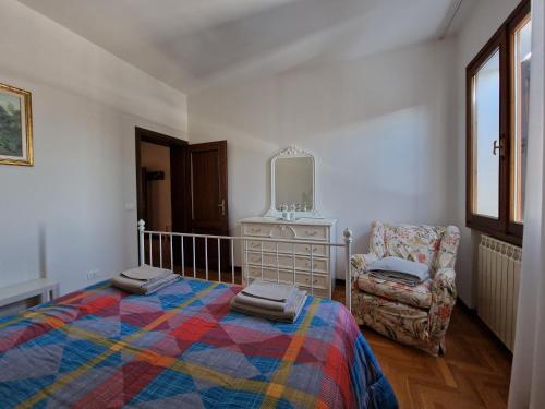 1 dormitorio con cama, silla y espejo en I Bócci, en Castel dʼAiano