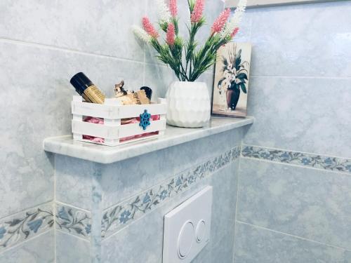 a shelf in a bathroom with flowers on it at Voce Del Mare - sea view- Alghero Airport in Alghero