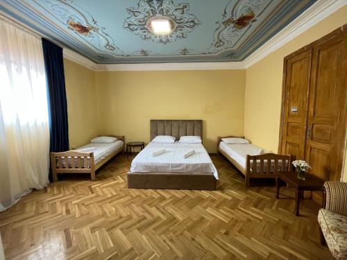 a bedroom with two beds and a blue ceiling at Tiflisi Hostel in Tbilisi City