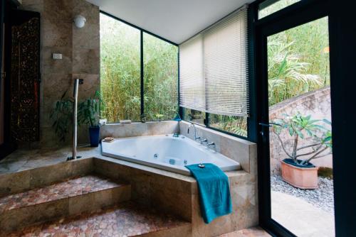 a bathroom with a bath tub with a large window at Riveresque in Margaret River Town