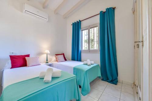 twee bedden in een kamer met blauwe gordijnen bij Villas Guzman - Beniali in Moraira