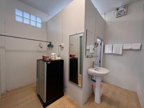 a bathroom with a sink and a toilet at Naisang Hostel in Chumphon