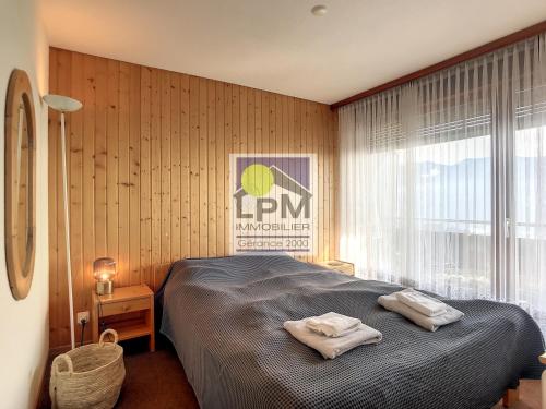 a bedroom with a bed with two towels on it at Alpha29 in Leysin