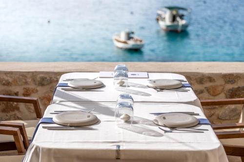 a table with a white table cloth with a view of the water at Pirgos Mavromichali in Limeni