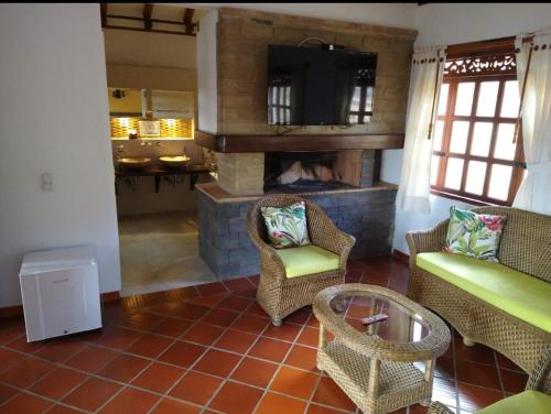 a living room with a fireplace and a couch and chairs at Hotel Bosque de la Villa in Villa de Leyva
