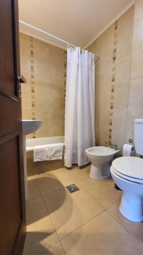 a bathroom with a toilet and a sink and a tub at Departamento Caseros in Salta