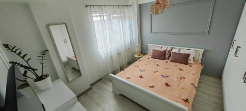 a small bedroom with a bed and a mirror at Apartament 1 Mai bloc nou-Self check-in in Craiova