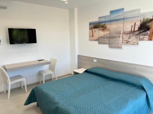 a bedroom with a bed and a desk and a television at B&B Casa Nicole in Peschici