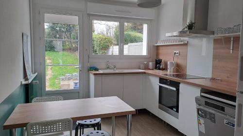 - une cuisine avec un comptoir, une table et 2 fenêtres dans l'établissement Entre Nausicaa et Wimereux, à Boulogne-sur-Mer