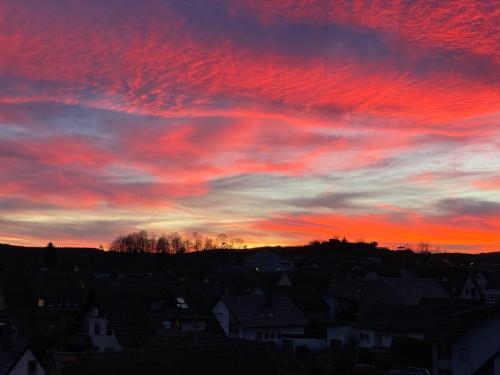 a sunset over a city with houses and roofs at Gasthof Rebland in Eichstetten